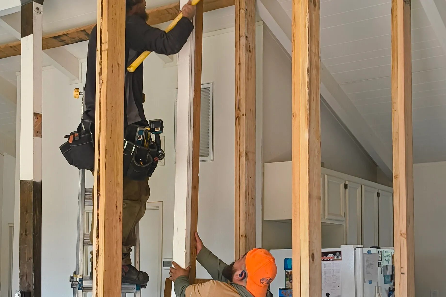 Two CCI Builders carpenters setting an interior wall stud