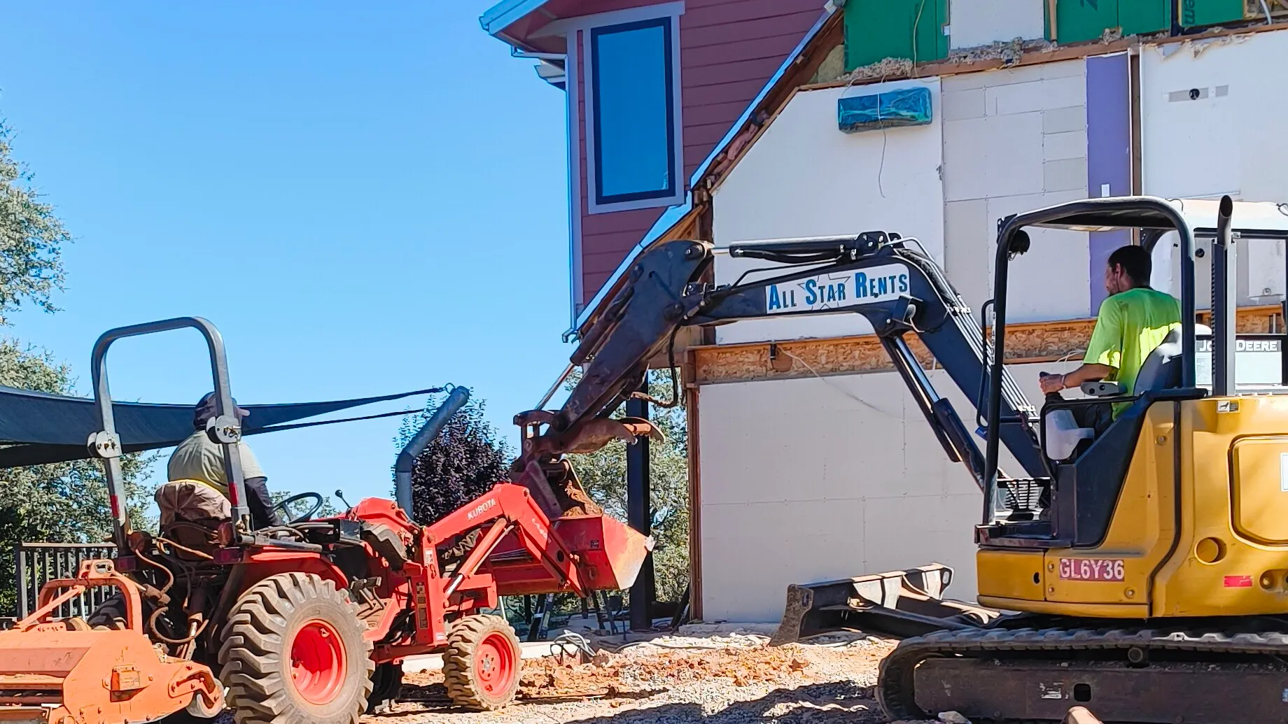 An excavator and tractor doing site prep on a CCI Builders build